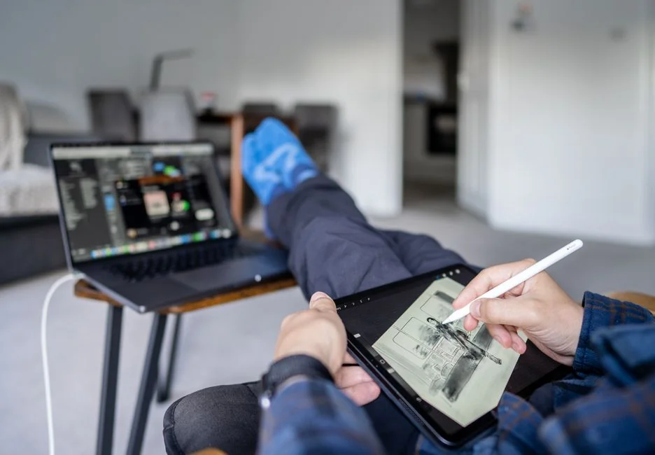 A close-up of a modern workspace, featuring a laptop and smartphone in use.
